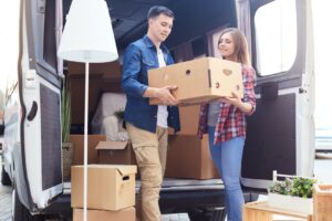 Couple grabbing boxes out of moving van.