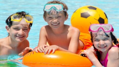 Three siblings posing for a picture in a pool.