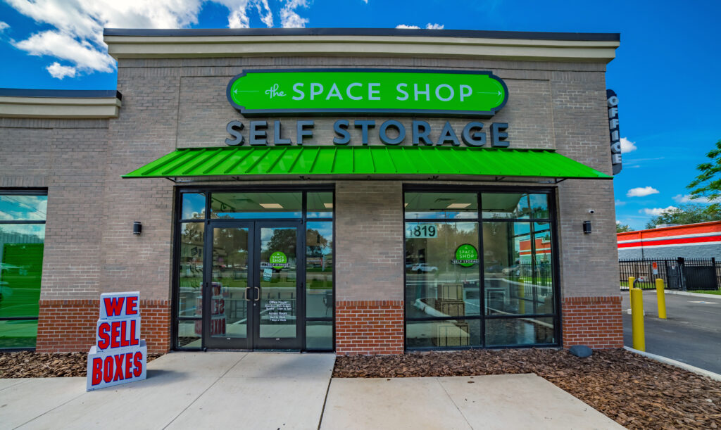 Outside of Space Shop Location With Large windows and Doors and a We Sell Boxes Sign.