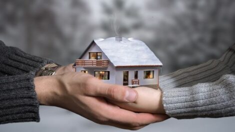 Couple holding hands acting as foundation of a house.