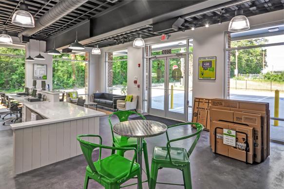 Entry of storage facility with tables and chairs, couches, and boxes to buy.